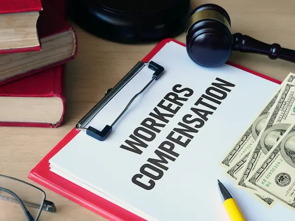 Workers' compensation coverage concept. A clipboard with money.