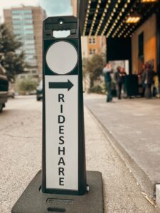 Rideshare directional sign indicating pickup area for Uber and Lyft passengers in urban setting.
