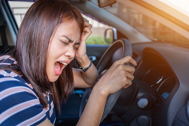 Woman in car expressing distress while holding steering wheel, illustrating emotional impact of car accidents relevant to Buford personal injury claims.