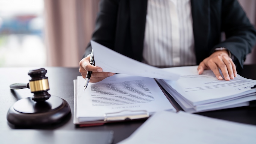 Lawyer reviewing legal documents with a gavel on the table, symbolizing legal representation for distracted driving accidents in Buford, Georgia.