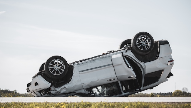 Car flipped on its side on road, representing the aftermath of a car accident, emphasizing the need for legal assistance in Marietta, GA.