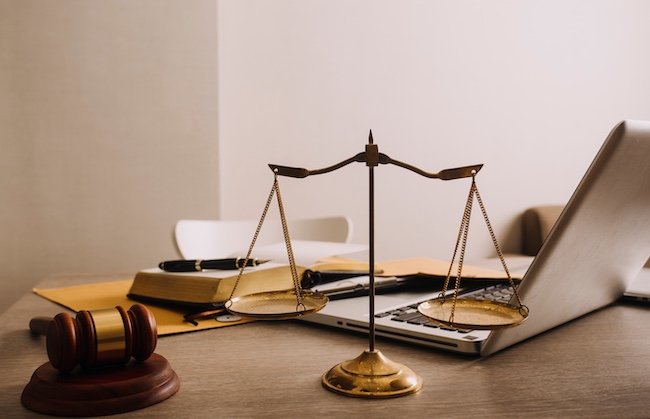Scales of justice in a law office setting with a gavel, legal documents, and a laptop, representing legal assistance for car accident cases in Marietta, Georgia.