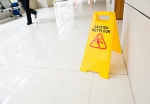 A caution sign for wet floor is set up in an airport to prevent workplace injury.