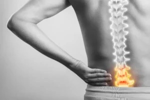 An inflamed spinal cord injury is superimposed over a worker's back.
