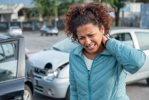 Woman holding neck in pain after a car accident