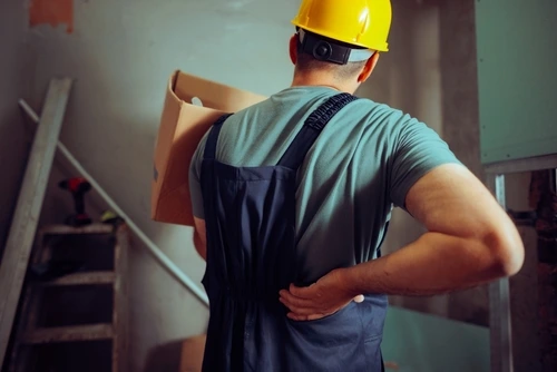 Construction worker with back pain from a repetitive motion injury