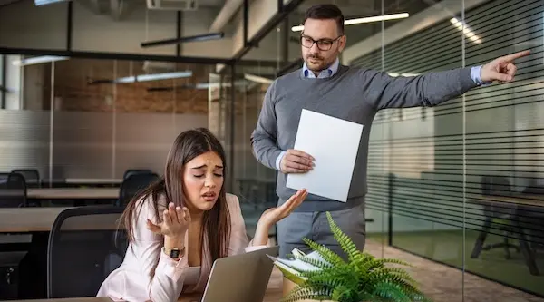 Workers' compensation retaliation scenario showing the employer confronting the employee in the office.