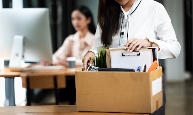 A wrongful termination victim is packing belongings after illegal dismissal from the workplace.